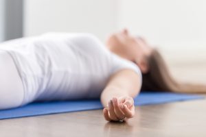 person in savasana practicing mindful fluidity